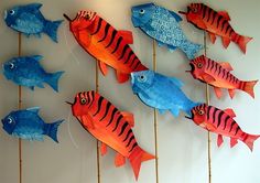 a group of paper fish hanging on a wall