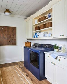 a washer and dryer in a room with white cabinets