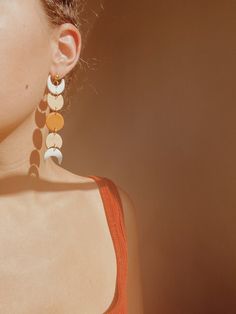 a close up of a person wearing earrings with circles on it's earring