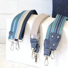 three straps are attached to the back of a white box with blue and green stripes