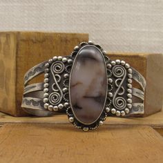 "Large sterling silver cuff bracelet with agate stone. Fred Harvey Era.  Oval stone with ornate silver work.  The bracelet is a wide split band with very nice stamp work. Good vintage condition with natural patina. The top is 2 7/8\" tall x 2 7/8\" wide. The inside measures 6 7/8\" including a 1 1/4\" opening. Lots of silver balls and scroll work in the design. Beautiful bracelet. Shipped by insured US first class mail. SBT-2" Artisan Silver Bracelet With Cabochon, Silver Artisan Bracelet With Cabochon, Antique Silver Gemstone Bracelet, Silver Cuff Bracelet With Cabochon, Handmade Oval Sterling Silver Bracelet In Vintage Style, Unique Silver Cuff Bracelet With Cabochon, Vintage Sterling Silver Bracelet With Gemstone, Vintage Cuff Bracelet With Natural Stones Gift, Vintage Agate Bracelet Jewelry