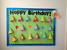 a birthday card with colorful hats and balloons on the front, hanging on a wall