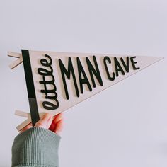 a person holding up a wooden sign that says choose man cave in black and white