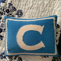 a blue and white pillow with the letter c on it