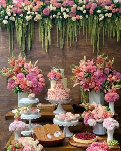 a table topped with lots of different types of cakes and cupcakes covered in flowers