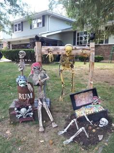 two skeleton statues sitting in front of a wooden cross and trunk with skeletons on it