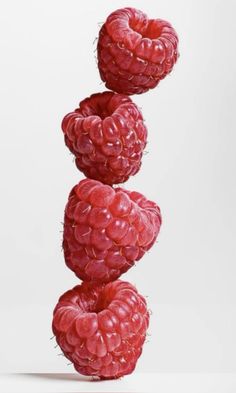 three raspberries stacked on top of each other in front of a white background