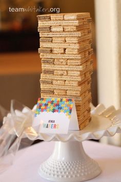 a stack of crackers sitting on top of a white cake plate with a card in the middle