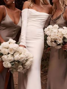 three beautiful women standing next to each other with bouquets in their hands and one holding flowers