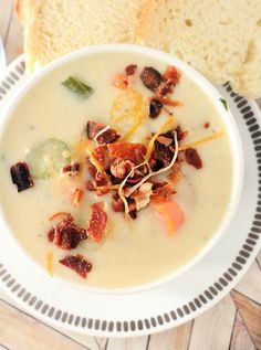 a white bowl filled with soup next to a slice of bread