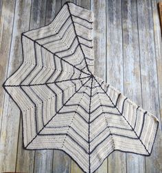 a crocheted spider web on top of a wooden floor