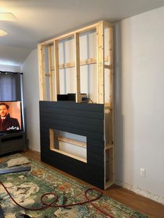 a living room area with a television, fireplace and entertainment center in the middle of it