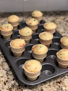 cupcakes with sprinkles are sitting in a muffin tin on the counter