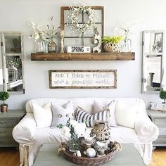 a living room filled with white furniture and lots of flowers on top of the coffee table