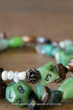 green and white beaded bracelets with numbers on each side, including two pine cone beads