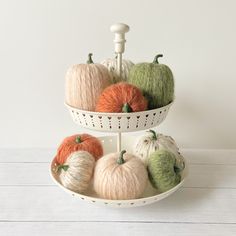 three tiered trays holding yarn balls and pumpkins