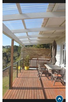 a wooden deck with chairs and an awning