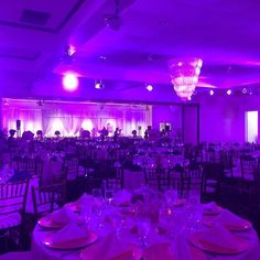 a room filled with lots of tables covered in purple lights