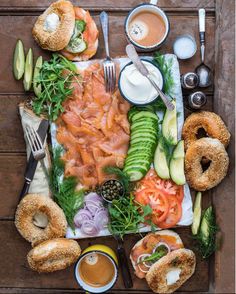 an assortment of food is laid out on a wooden table with utensils and sauces