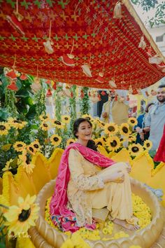 a woman sitting on top of a bed of flowers