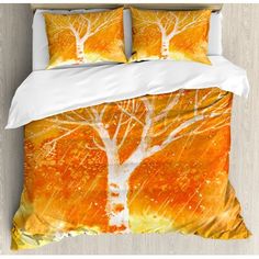 an orange and white bed with two trees on the cover is featured in this image