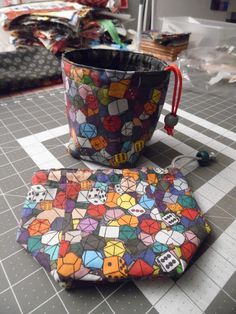 a colorful bag sitting on top of a table next to a small pouch filled with dices