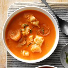 there is a bowl of soup with dumplings in it and another bowl next to it