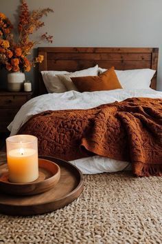 a bedroom with a bed, tray and candle on the floor in front of it