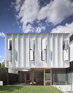 an architecturally designed building with white shutters on the side