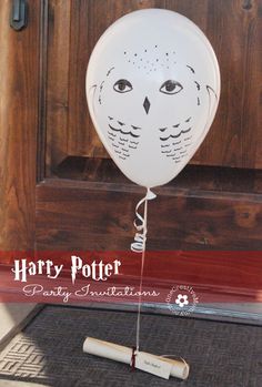 a white balloon with an owl face on it sitting in front of a wooden door