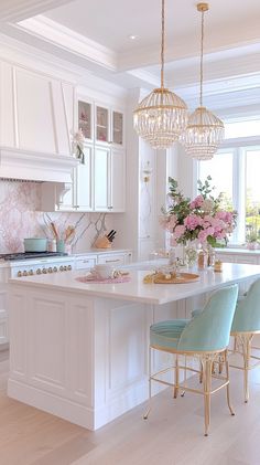 a large kitchen with white cabinets and marble counter tops, along with light blue chairs