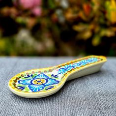 a ceramic object sitting on top of a table next to some flowers in the background