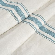 two blue and white striped sheets laying on top of each other