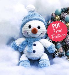 a crocheted snowman sitting next to a christmas wreath with the text free pattern