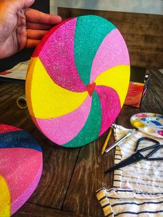 a colorful beach ball sitting on top of a wooden table next to some scissors and other items