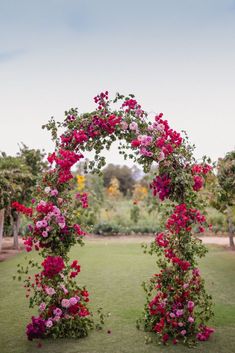 an outdoor wedding ceremony with pink flowers and greenery