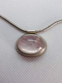 Signed AK Sterling Silver oval Light Pink Rose Quartz east to west sideways pendant on a 16" snake chain.The designer hallmark is an AK that is conjoined,The light pink rose quartz shows any inclusions, this is normal for cabochons of this type.Stunning Pink to Clear Quartz coloration of the cabochon stoneThe pendant is an east to west sideways oval and measures in at 1 " x 3/4", Nice heavy weight. Beautiful snake chain 16" is included for you.Clasp: spring-ringMetal: sterling silver 925 markedW Silver Gemstone Necklace, Pink Quartz Jewelry, Rose Quartz Pendant Necklace, Rose Quartz Necklace Pendants, Quartz Pendant Necklace, Light Pink Rose, Pink Rose Quartz, Rose Quartz Pendant