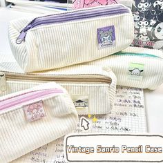 three white pencil cases sitting next to each other on top of a desk covered in papers