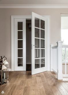 an empty room with wooden floors and white doors