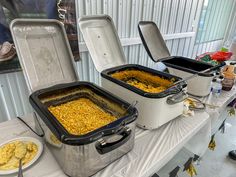 two coolers filled with food sitting on top of a table next to each other