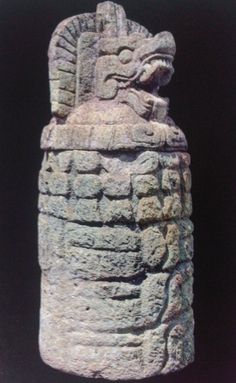 a stone statue with an animal head on it's back end, against a black background