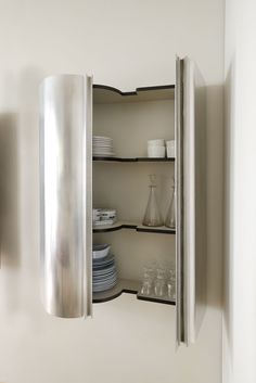 an open cabinet with plates and cups in it