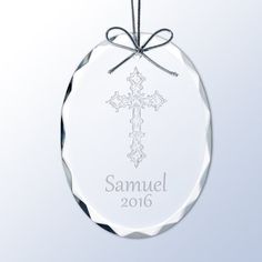 a clear glass ornament with a cross on it's side and the name samuel