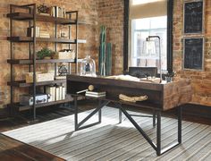 an industrial style home office with exposed brick walls and open shelving, leather chair, desk, and art on the wall