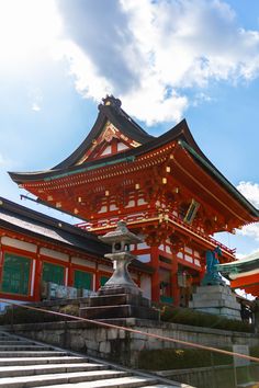 a tall red building sitting on top of a lush green field