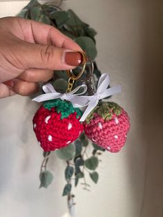 two crocheted strawberries hanging from a keychain