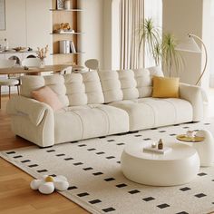 a living room filled with white furniture and lots of windows