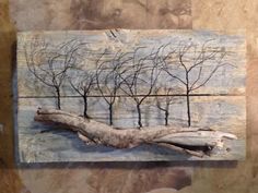 a piece of art that has been made to look like trees on a wooden board