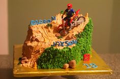 a cake that is shaped to look like a mountain bike rider on top of a hill