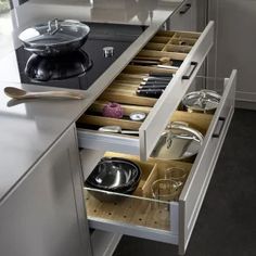 an open drawer in the middle of a kitchen